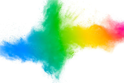 Defocused image of multi colored powder paints against white background