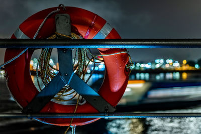 Close-up of illuminated red boat in river against sky