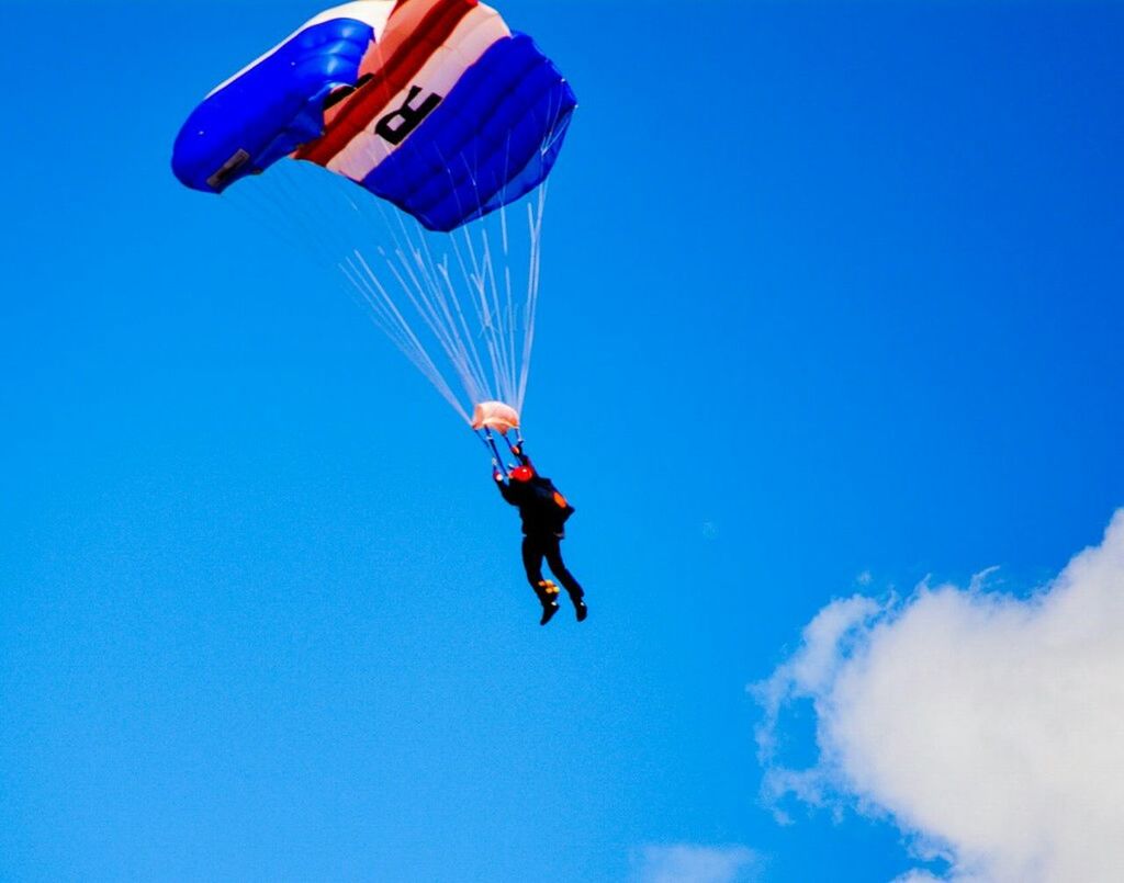mid-air, blue, flying, extreme sports, leisure activity, parachute, motion, freedom, adventure, lifestyles, exhilaration, sport, full length, jumping, skill, vitality, low angle view, paragliding