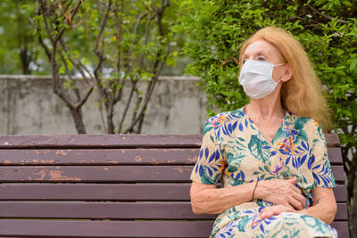 Woman sitting on bench in park