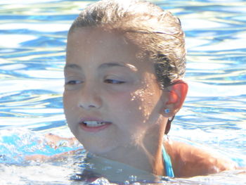 Close-up portrait of smiling man swimming in pool