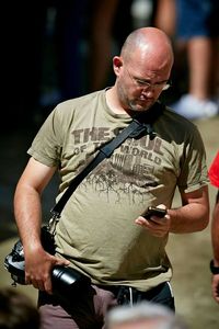 Midsection of man holding camera while standing outdoors