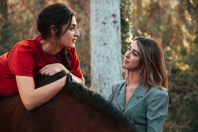 Beautiful women standing with horse in forest