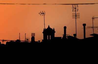 Low angle view of silhouette buildings against clear sky during sunset