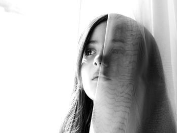 Close-up portrait of young woman against white background