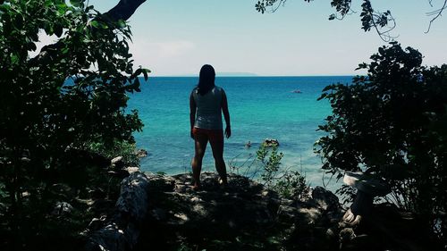 Rear view of woman standing on beach