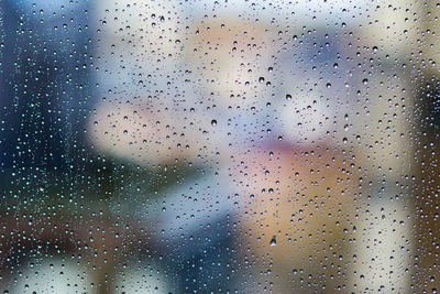 Full frame shot of wet glass window during rainy season