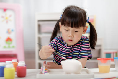 Young girl painting craft at home 