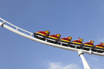 Low angle view of amusement park ride against blue sky