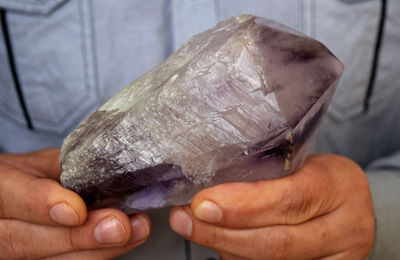 Midsection of man holding quartz