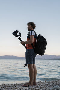 Full length of man standing on beach against clear sky