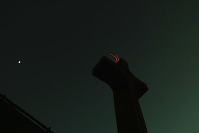 Low angle view of cross against clear sky at night