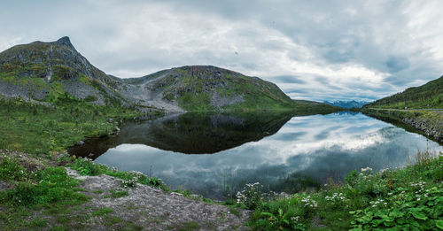 Scenic view of lake by mountain against sky