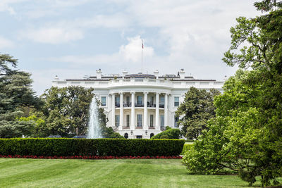 Grassy field with white house in background