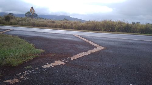Road by street in city against sky