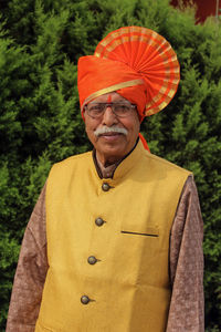 Portrait of smiling man standing against orange wall