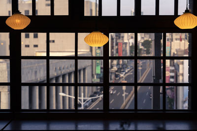 Close-up of illuminated pendant lights hanging from window