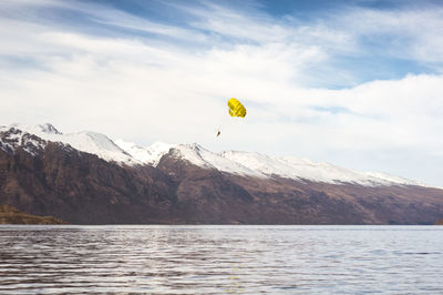 Distant person paragliding over wakatipu lake