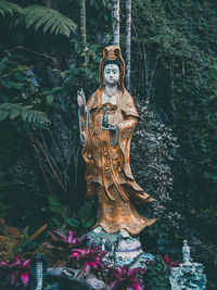 Statue against trees and plants