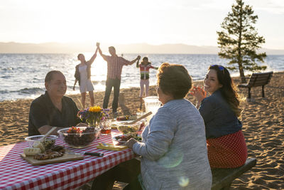 A family enjoys a beach bbq on the shoreline of lake tahoe, nv