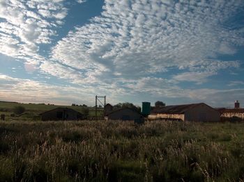 View of grassy field against cloudy sky