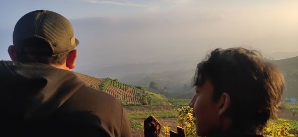 Rear view of woman looking at mountains against sky