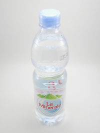 Close-up of glass of bottle against white background