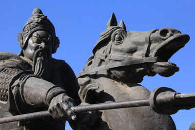 Low angle view of statue against blue sky