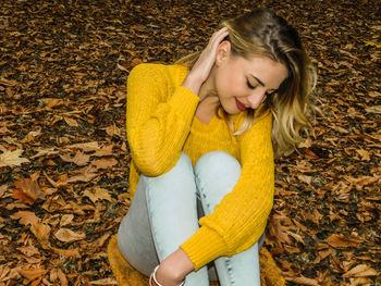 Young woman lying down on autumn leaves