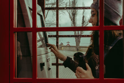 Young woman using payphone outdoors