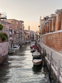 Boats in canal amidst buildings in city