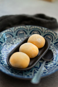 Yellow-colored japanese mochi in rice dough and on a pattern blue plate background.