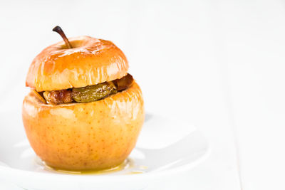 Close-up of apple on plate against white background