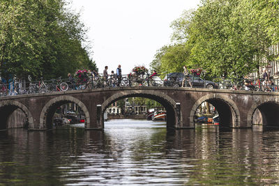 Arch bridge over river against sky