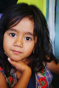 Close-up portrait of cute girl sitting at home