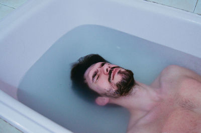 View of handsome man in bathtub 