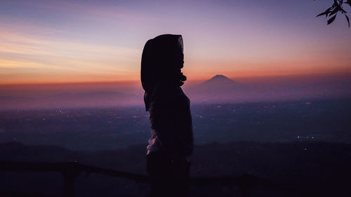 Silhouette woman standing against sky during sunset