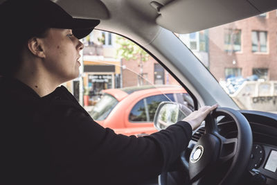 Side view of female driver driving truck in city