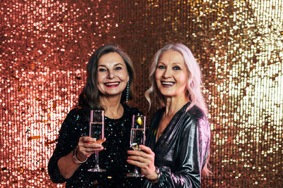 Portrait of smiling friends holding champagne