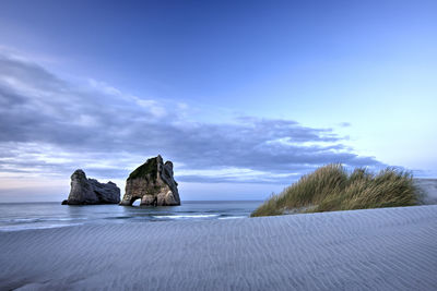 Rocks on beach against sky