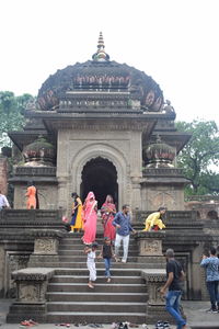 Group of people outside temple against building