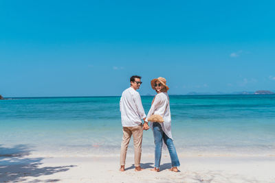 Portrait of couple standing at beach 