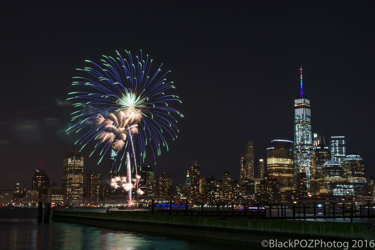 illuminated, night, building exterior, architecture, built structure, city, arts culture and entertainment, ferris wheel, firework display, water, tall - high, travel destinations, clear sky, cityscape, skyscraper, sky, long exposure, tower, waterfront, river