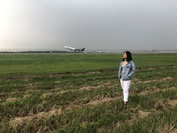 Woman standing on grass against sly