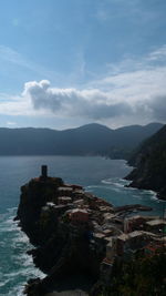 Scenic view of sea by mountains against sky