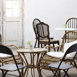 Empty chairs and table against wall