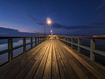 Surface level of footbridge over sea against sky