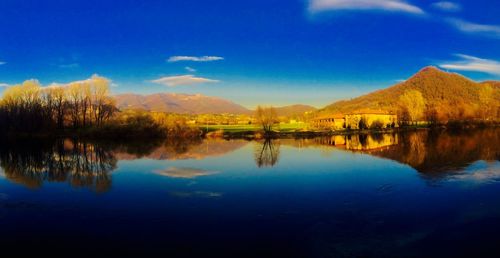 Scenic view of lake by trees against sky