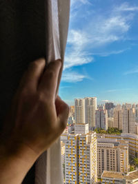 Cropped image of person against buildings in city