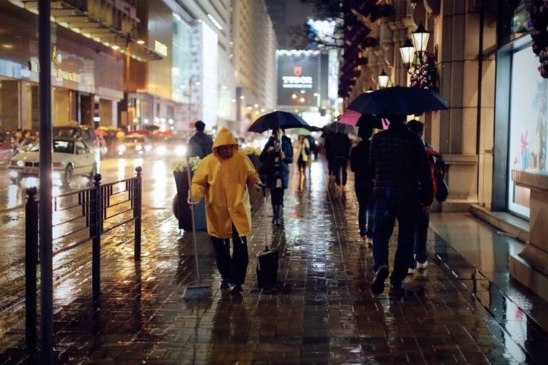 indoors, men, reflection, lifestyles, glass - material, person, transparent, leisure activity, architecture, retail, built structure, incidental people, rear view, illuminated, standing, city life, high angle view